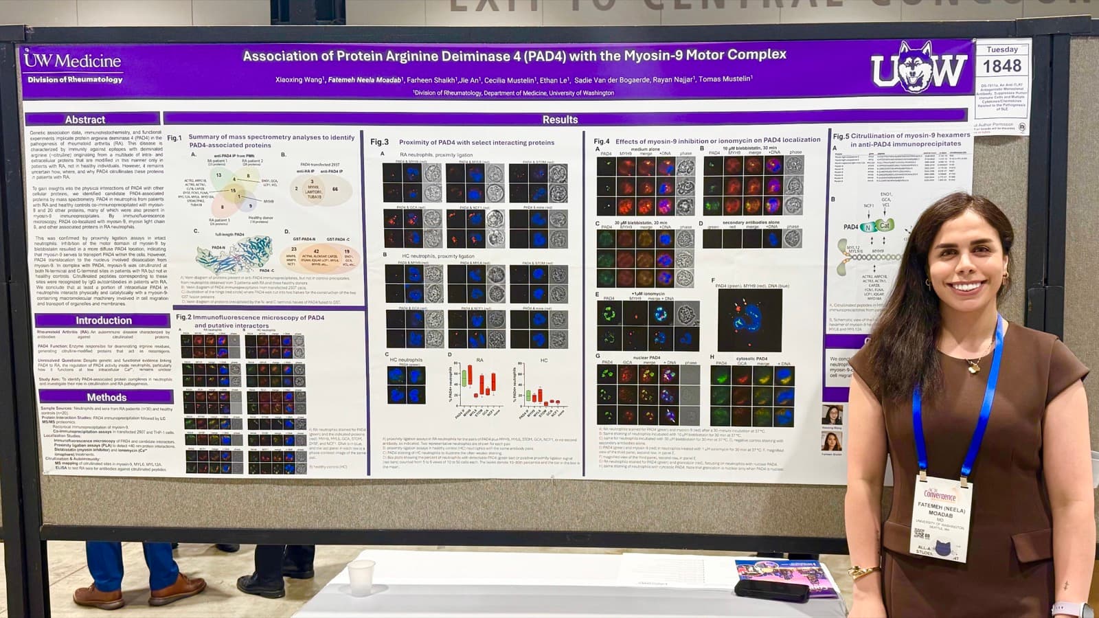 Dr. Neela Moadab standing beside a research poster on PAD4 and the myosin-9 motor complex